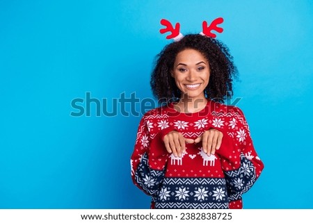 Photo of carefree person woman toothy smiling makes paws gesture wearing red deer horns at xmas party isolated on blue color background