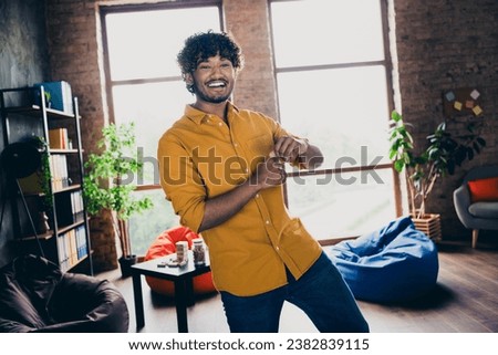 Photo portrait of attractive young man wear yellow shirt excited dancing have fun modern workplace room home design