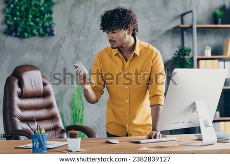 Photo of confident successful man dressed trendy clothes writing reading sms workstation indoors