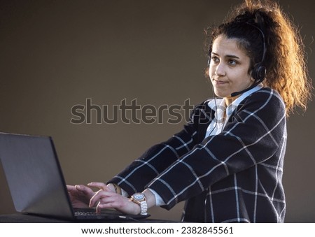 Pretty young woman with headphones and microphone working on customer service position
