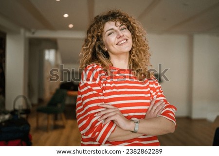 One woman caucasian female happy confident stand indoor at cafe with curly hair portrait smile real person copy space