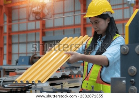 Female industrial technician holding a tablet works at an industrial plant. Technician inspecting and repairing machinery, safety concept