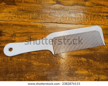 white comb lying on brown wooden table