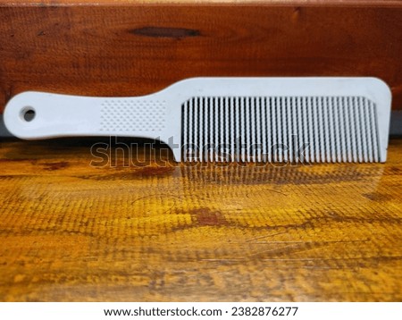 White comb lying on brown wooden table