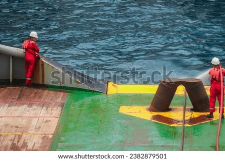 The ship's crew is cleaning the towing wire using a fire hydrant when the towing wire pays in after being used for anchor handling Royalty-Free Stock Photo #2382879501