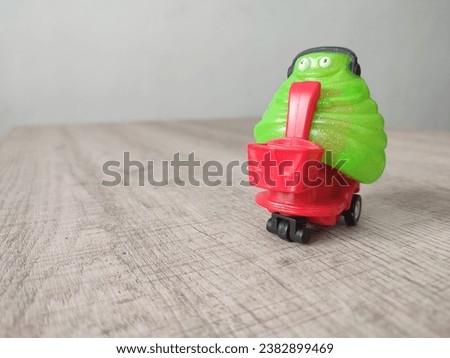 Green monster toy smiles while listening to music
