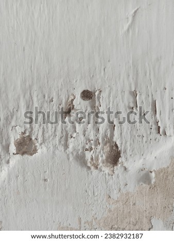 The texture of the old house wall paint is worn away by age with the coating paint peeling and becoming brownish in color Royalty-Free Stock Photo #2382932187