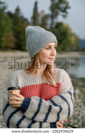 Smiling woman in warm clothes at lake