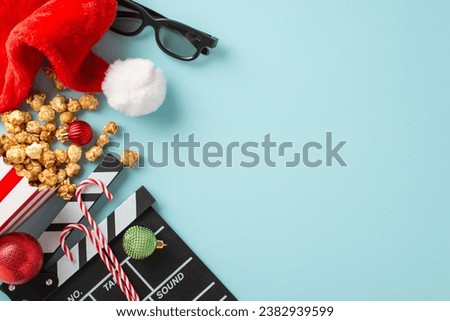 Holiday Movie Night: Top view of a movie clapper, 3D glasses, striped popcorn box, Santa's hat, baubles, thematic candies on a light blue surface with space for advertising