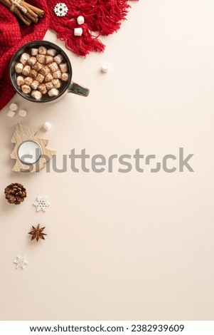 Revel in wintertime allure through top-view vertical shot. Luscious hot chocolate cup, embellished with cinnamon, anise, candle, pine cone, intricate snowflakes, cozy scarf on soothing pastel backdrop