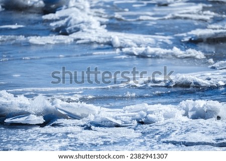 Frozen sea surface with fragments of ice, natural background photo with selective soft focus