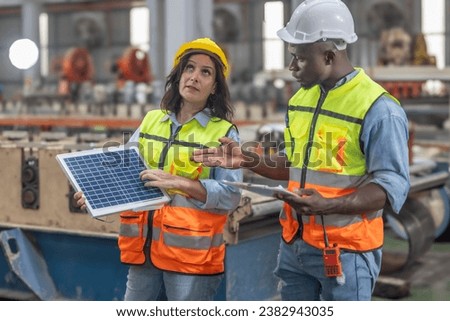 Metal sheet workers at factory plan to install solar panels on roof, promoting renewable energy, reducing costs, registering carbon credits for sustainable and efficient way to combat climate change. Royalty-Free Stock Photo #2382943035