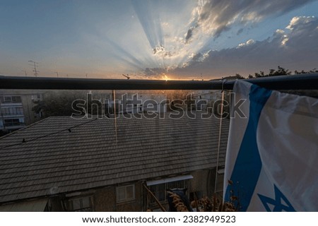 High resolution panoramic wide angle image of an urban setting with a beautiful sunset in the background with an Israeli flag
