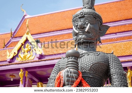 Thao Wessuwan or Vasavana giant statue, the church is a blurry background. at Bang Chak Temple, Nonthaburi Province