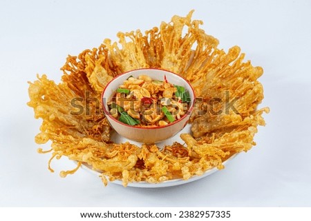 Crispy fried golden needle mushrooms with spicy salad can be served as an appetizer.