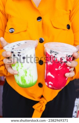 fresh and cold iced boba drink being held in hand