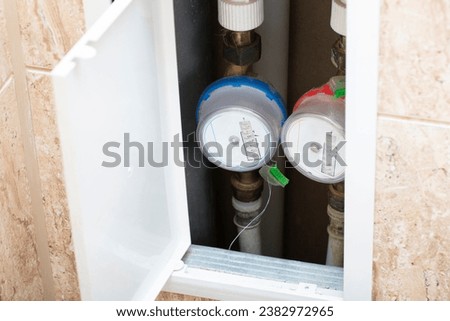 Installation of a meter for cold and hot water. Replacement of water meters by a plumber. Royalty-Free Stock Photo #2382972965