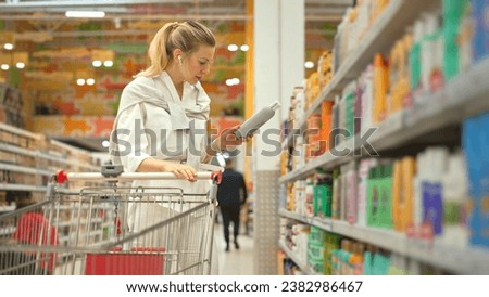40s woman buy bio shampoo bottle. Blond girl choose eco hair gel. Lady take item put cart. Body care row. Customer read shampoo label beauty store. Buyer pick up lotion cosmetic shop. Hand hold soap. Royalty-Free Stock Photo #2382986467