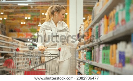 40s woman buy bio shampoo bottle. Blond girl choose eco hair gel. Lady take item put cart. Body care row. Customer read shampoo label beauty store. Buyer pick up lotion cosmetic shop. Hand hold soap. Royalty-Free Stock Photo #2382986477