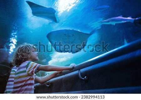 Family in aquarium. Kids watch tropical fish, marine life. Child looking at sea animals in large oceanarium. Ocean life museum. School or vacation day trip to aqua park. Royalty-Free Stock Photo #2382994113