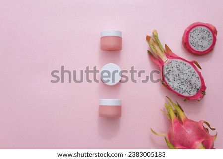 Capture a top-down view of an unlabeled cosmetic jar surrounded by fresh dragon fruit and props on a pastel backdrop. Perfect for health and beauty-themed magazines, this image exudes elegance.