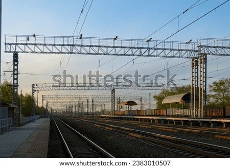 Railway and infrastructure and power lines at sunset
