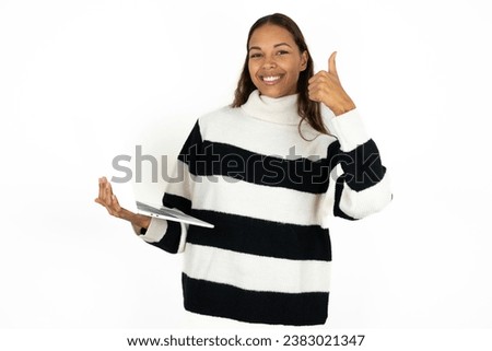 Beautiful attractive young beautiful business woman wearing striped sweater hold netbook hand finger show thumb up
