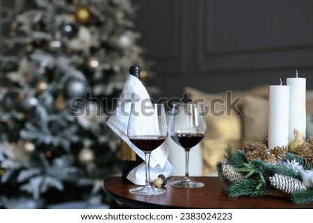 Red wine glasses and christmas balls on snow