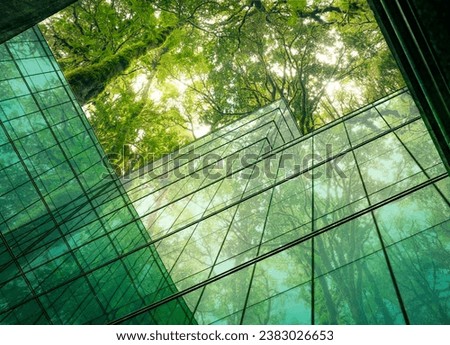 Eco-friendly building in the modern city. Sustainable glass office building with tree for reducing heat and carbon dioxide. Office building with green environment. Corporate building reduce CO2. Royalty-Free Stock Photo #2383026653