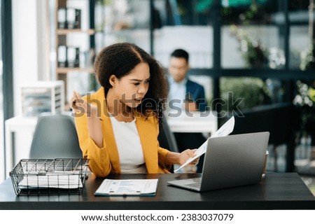 Asian business woman is stressed, bored, and overthinking from working on a tablet at the modern office.
