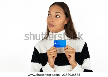 Photo of cheerful beautiful dark haired woman hold debit card look empty space
