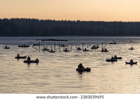 Sport fishing. Silhouettes of fishermen on inflatable boats on the surface of the water.