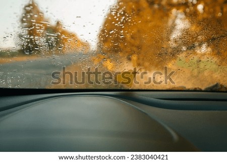 Car window with raindrops, autumn wallpaper.