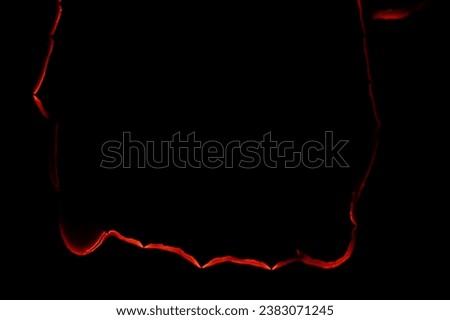 burning paper, glowing edge of paper on a black background Royalty-Free Stock Photo #2383071245