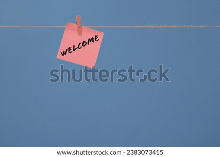 Word WELCOME written on memo sticky note and isolated on blue background with copy space for texts, logo, photo...
