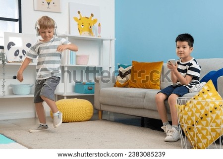 Cute little boys playing with gadgets at home