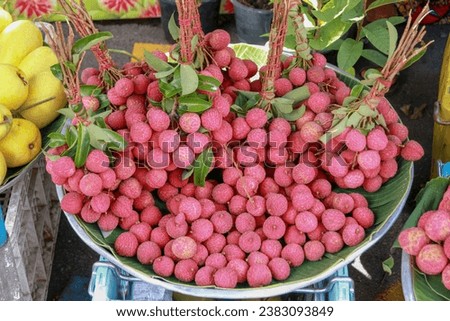 Red lychees with banana leaves on a tray 