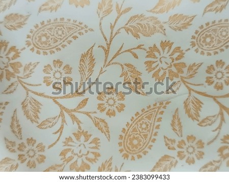 Abstract golden flower and leaf design on a clean white backdrop.