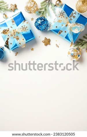 Vertical Christmas background with blue and gold decorations, gift boxes on white background. Top view. Flat lay.