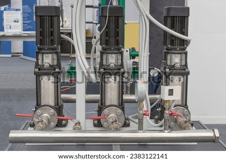 A system of three vertical circulation pumps at the exhibition stand Royalty-Free Stock Photo #2383122141