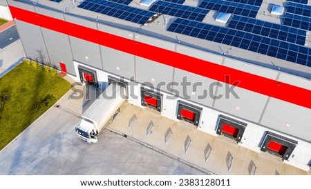 Industry with low carbon footprint. Industrial warehouses with solar panels on the roof. Technology park and factories  from above.