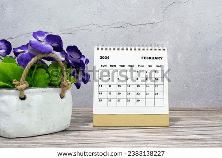 White calendar on office wooden desk with potted plant. 2024 New Year Concept