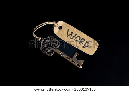 Antique old key with WORD tag on black background