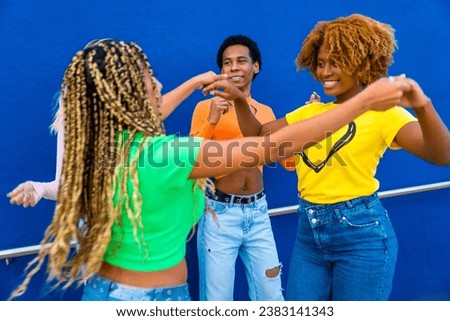Dynamic photo of happy multiracial friends dancing together holding hands outdoors