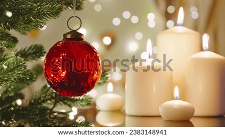 Christmas concept red glass ball rotate on branch Christmas tree close-up burning candles bokeh flickering light bulbs garlands. Happy New Year. Noel. Decorated Christmas tree. Winter holidays family