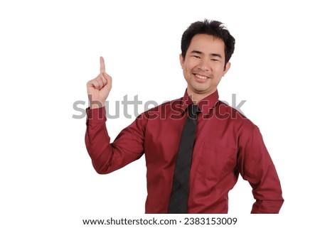Asian male businessman pointing his finger at empty space, smiling face
