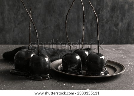Plate with tasty caramel apples for Halloween on black background
