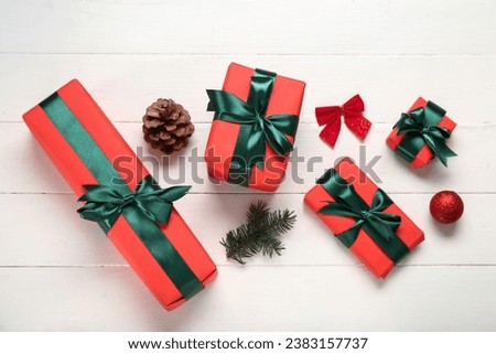 Gift boxes with Christmas decorations on white wooden background