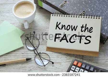 KNOW THE FACTS a cup of coffee. glasses. two office folder gray notepad. text on the page