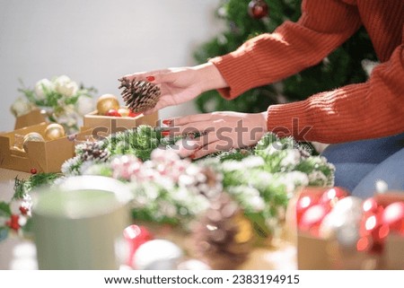 Woman making mistletoe wreath Christmas wreath decoration with hand made DIY winter greenery florist hands making Christmas wreath beautiful mistletoe